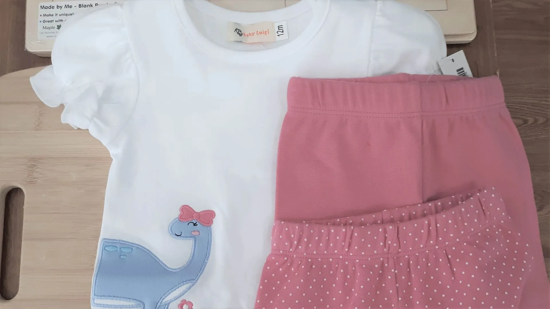White tee with a dinosaur appliqué and pink shorts for little girls